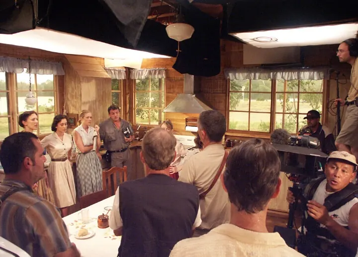 Cast and crew filming a scene around the kitchen table on the End of the Spear set