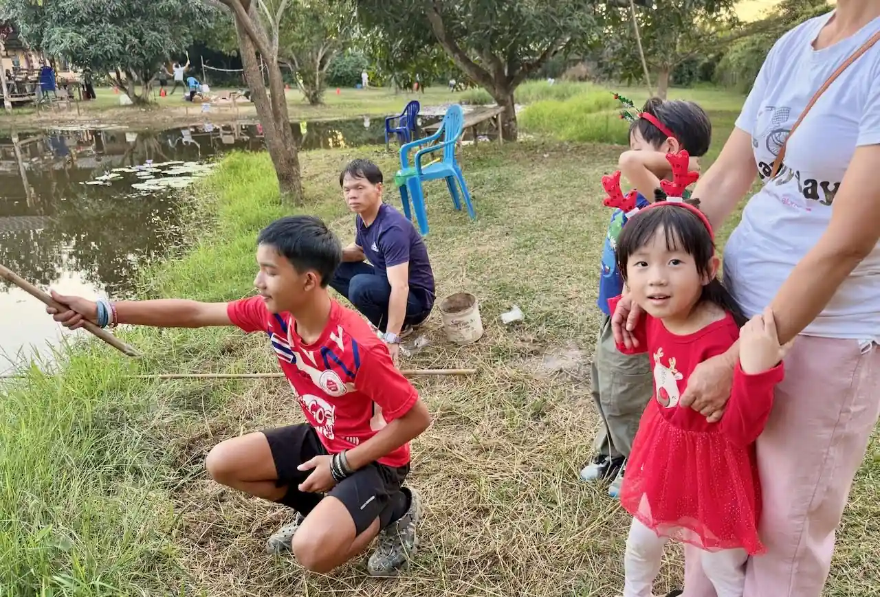 Family fishing together at the Camp 99 pond