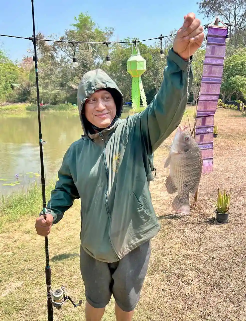 Visitor holding up a fish caught at the Camp 99 pond