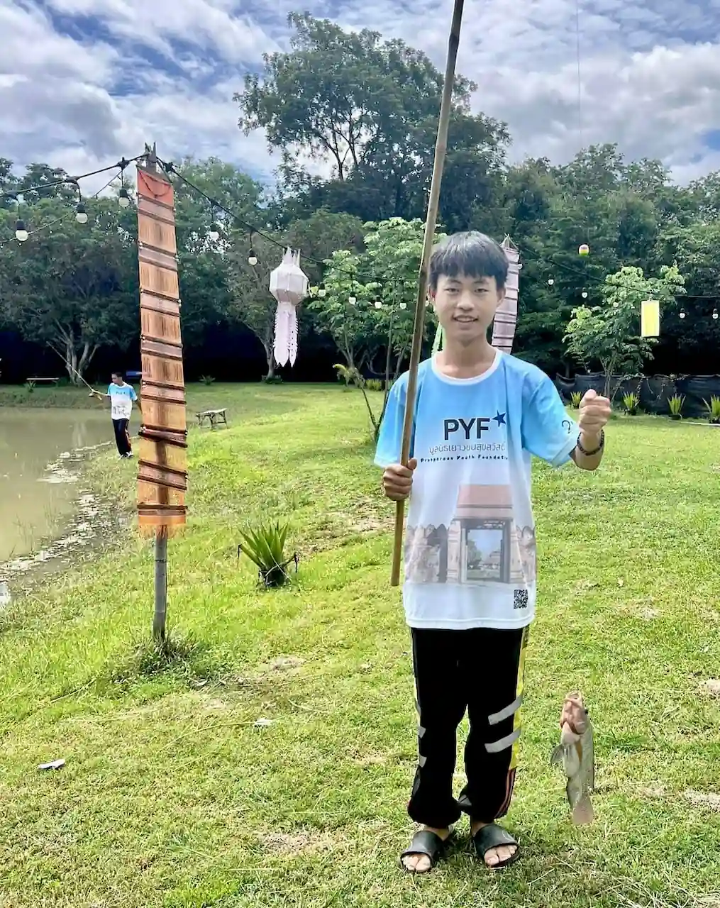 Boy showing off his catch at the Camp 99 pond