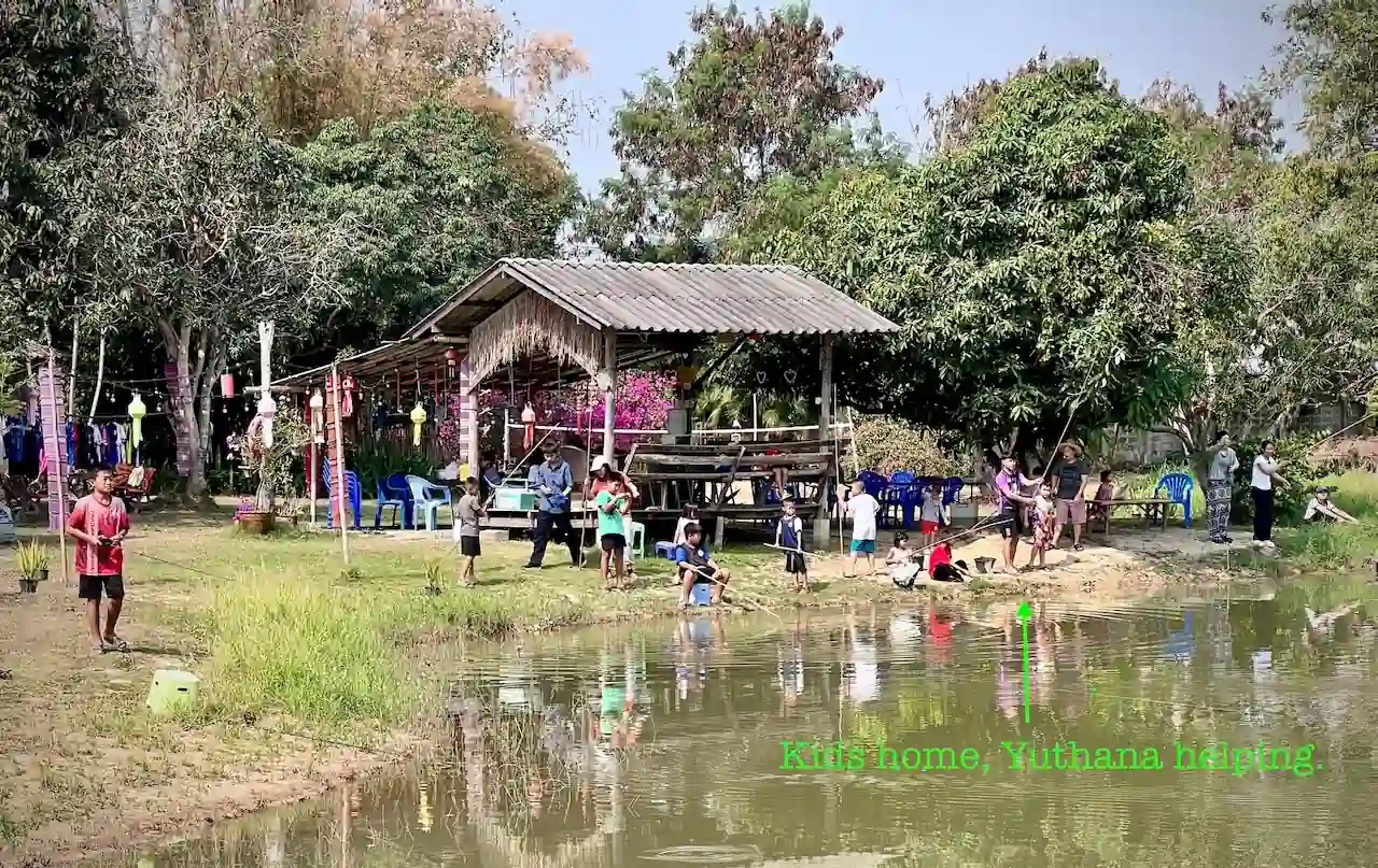 Sala and pond at Camp 99 with visitors gathered near the water