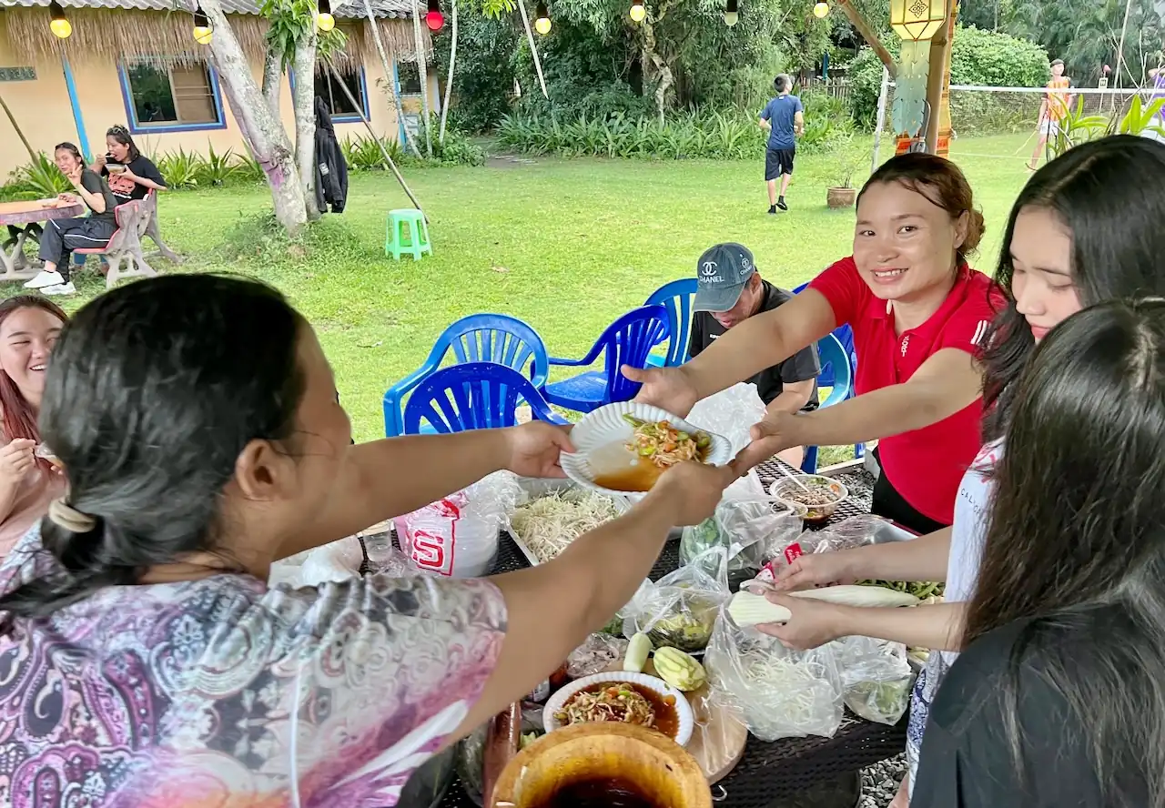 Church group sharing picnic food at Camp 99